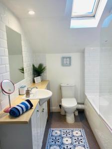 a bathroom with a sink and a toilet and a tub at The Old Queens Stable on Sea in Hollington +25 photos