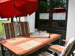 drewniany stół z parasolem na patio w obiekcie Holiday Home Am Sternberg 105 by Interhome w mieście Frankenau