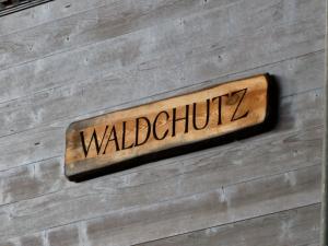 een bord aan de zijkant van een muur met het woord Walcliffe bij Apartment Chalet Waldchutz - 2- Stock by Interhome in Lenk