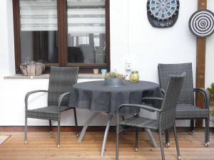 a table with chairs and a clock on a patio at Apartment Petra-2 by Interhome in Frankenhain