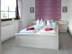 a bedroom with a white bed with pillows on it at Apartment Petra-2 by Interhome in Frankenhain