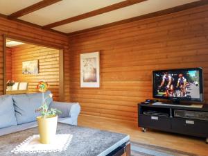 a living room with wooden walls and a flat screen tv at Apartment Ferienpark Himmelberg-2 by Interhome in Thalfang