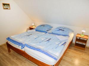 a bed in a room with two blue pillows on it at Apartment Gollwitzer Park - Insel Poel-6 by Interhome in Gollwitz