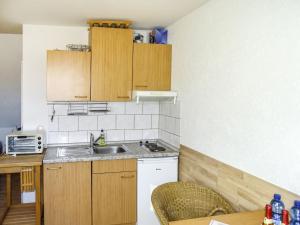 a small kitchen with wooden cabinets and a sink at Apartment Gollwitzer Park - Insel Poel-6 by Interhome in Gollwitz
