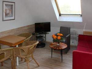 a living room with a couch a table and a tv at Apartment Gollwitzer Park - Insel Poel-6 by Interhome in Gollwitz