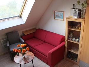 a living room with a red couch and a table at Apartment Gollwitzer Park - Insel Poel-6 by Interhome in Gollwitz