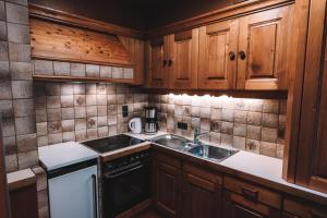 a small kitchen with wooden cabinets and a sink at Alpenherz Chalet in Elbigenalp