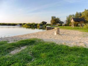 a beach with a gazebo next to a lake at Apartment Achterwasserblick by Interhome in Dewichow