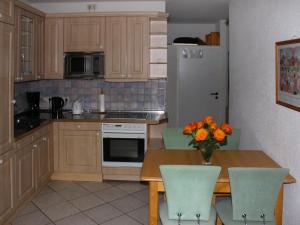 a kitchen with a table with a vase of flowers on it at Apartment Gollwitzer Park - Insel Poel-9 by Interhome in Gollwitz