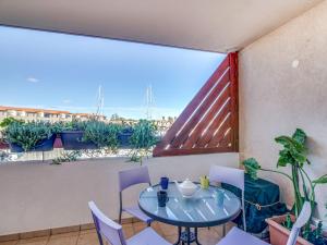 a table and chairs on a balcony with a view at Apartment Les Quais de L'Amirauté-7 by Interhome in Saint Cyprien Plage