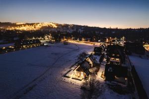 una vista aérea de una ciudad en la nieve por la noche en Osada Białka Tatrzańska - apartamenty & domki z ogrodem dla rodzin Odkryj-Bialke, en Białka Tatrzanska