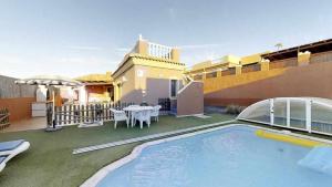 a house with a swimming pool and a patio at Anju Villas Villas Vistas del Mar in Corralejo