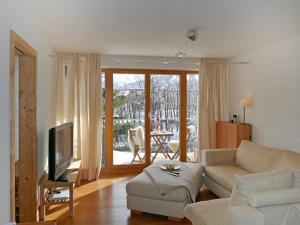 a living room with a couch and a tv at Apartment Chesa San Bastiaun B5 by Interhome in Samedan