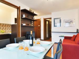 - une salle à manger avec une table et un canapé rouge dans l'établissement Apartment Enrosadira-6 by Interhome, à Alba di Canazei