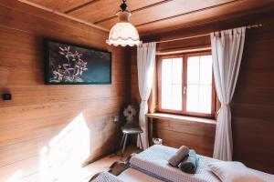 Schlafzimmer mit Holzwänden und einem Bett mit Fenster in der Unterkunft Alpenherz Chalet in Elbigenalp