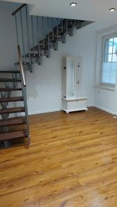 um quarto vazio com uma escada e um piso de madeira em Apartments SMAG Barbiergasse em Pirna