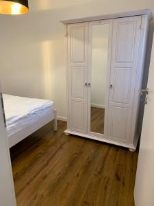 a bedroom with a white cabinet and a bed at Apartments SMAG Barbiergasse in Pirna
