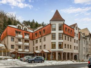 un grand bâtiment avec des voitures garées devant lui dans l'établissement Apartment Lanovka-7 by Interhome, à Jáchymov