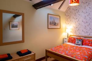 a bedroom with a bed and a mirror at River Nene Cottages in Water Newton