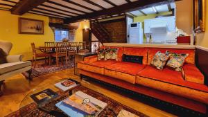 ein Wohnzimmer mit einem roten Sofa und einem Tisch in der Unterkunft River Nene Cottages in Water Newton