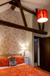 a bedroom with a bed with an orange comforter at River Nene Cottages in Water Newton