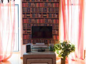 a living room with a tv and a wall of books at Apartment Regina Ottavia by Interhome in Rome