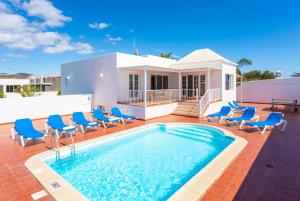 uma villa com uma piscina e cadeiras azuis em Villa Candela em Mácher