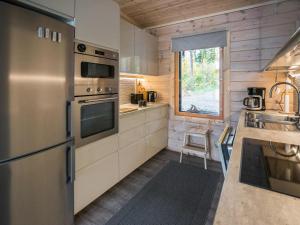 a kitchen with stainless steel appliances and a window at Holiday Home Villa kurki by Interhome in Torvoila