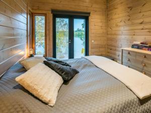 a bedroom with a bed in a wooden cabin at Holiday Home Villa kurki by Interhome in Torvoila