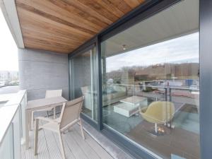 a balcony with glass doors and a table and chairs at Apartment Sea Breeze by Interhome in Bredene