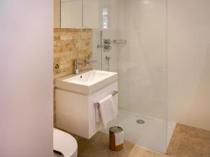 uma casa de banho com um WC, um lavatório e um chuveiro em Apartment Chesa Palüdin 5 - Celerina by Interhome em Celerina