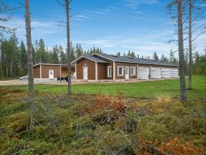ein Haus mitten auf einem Feld mit Bäumen in der Unterkunft Holiday Home Levin revontulitaivas a by Interhome in Köngäs