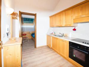 Una cocina con gabinetes de madera y un fregadero. en Apartment Enrosadira-7 by Interhome, en Alba di Canazei
