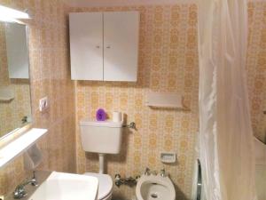 a bathroom with a white toilet and a white cabinet at Apartment Enrosadira-7 by Interhome in Alba di Canazei