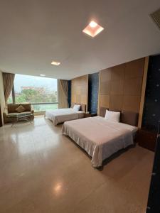 Habitación de hotel con 2 camas y ventana en Charming Motel, en Hualien City