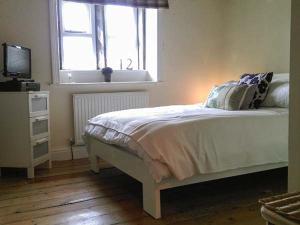 a bedroom with a bed and a window and a television at 12 Rattle Row in Holmfirth