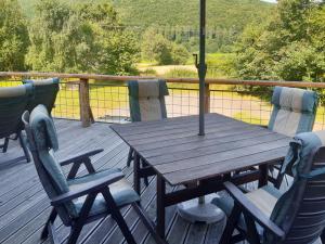 a wooden table and chairs on a deck at Chalet Haus am Fluss by Interhome in Wahmbeck