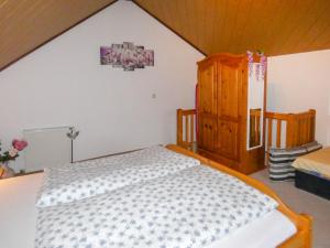 a bedroom with a bed and a wooden cabinet at Holiday Home Panoramablick by Interhome in Piesau