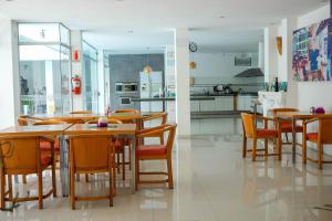 una cucina e una sala da pranzo con tavoli e sedie in legno di Hotel Senses Equipetrol a Santa Cruz de la Sierra