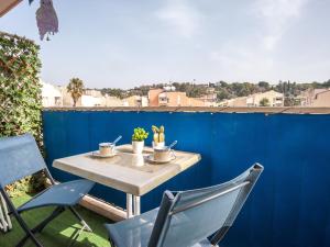 a table and chairs on a patio with a blue fence at Apartment L'Amiral-1 by Interhome in Cagnes-sur-Mer