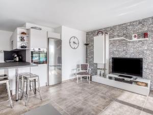 a living room with a tv and a brick wall at Apartment Le Jardin du Loderi-1 by Interhome in Bormes-les-Mimosas