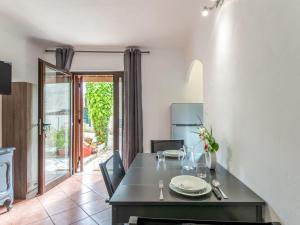 a dining room with a table and a kitchen with a door at Apartment Le Narcisse by Interhome in Cagnes-sur-Mer