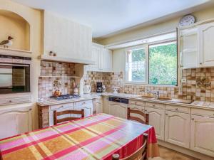 a kitchen with white cabinets and a table and a window at Holiday Home Coët A Tous by Interhome in Carnac