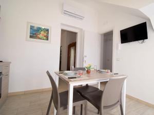una sala da pranzo bianca con tavolo e sedie di Apartment Ginestra SinAgo by Interhome a Lascari