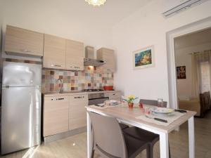 a kitchen with a table and a stainless steel refrigerator at Apartment Ginestra SinAgo by Interhome in Lascari