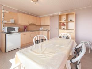 a kitchen with a table and chairs and a microwave at Apartment Empaja great views and parking by Interhome in De Haan