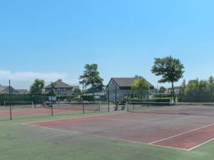 um campo de ténis com pessoas a jogar nele em Apartment Empaja by Interhome em De Haan