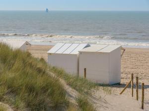 two buildings on a sandy beach near the ocean at Apartment Empaja great views and parking by Interhome in De Haan +8 photos
