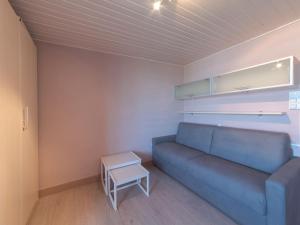 a living room with a blue couch and a table at Apartment Empaja great views and parking by Interhome in De Haan
