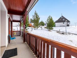 eine Veranda mit einem blauen Stuhl und einem schneebedeckten Hof in der Unterkunft Holiday Home Holiday Hill 67 by Interhome in Lauterwasser